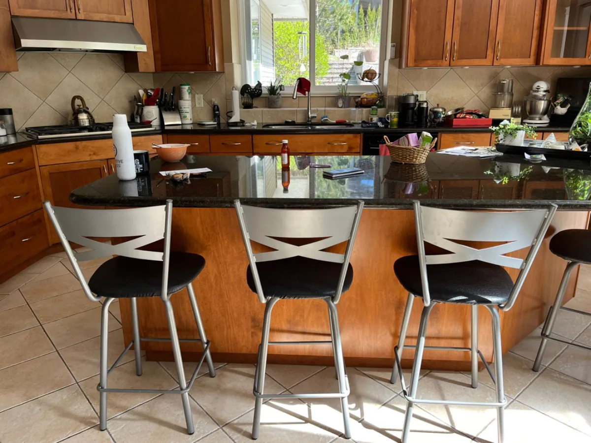 Kitchen island before renovation with cherry wood and black granite countertop