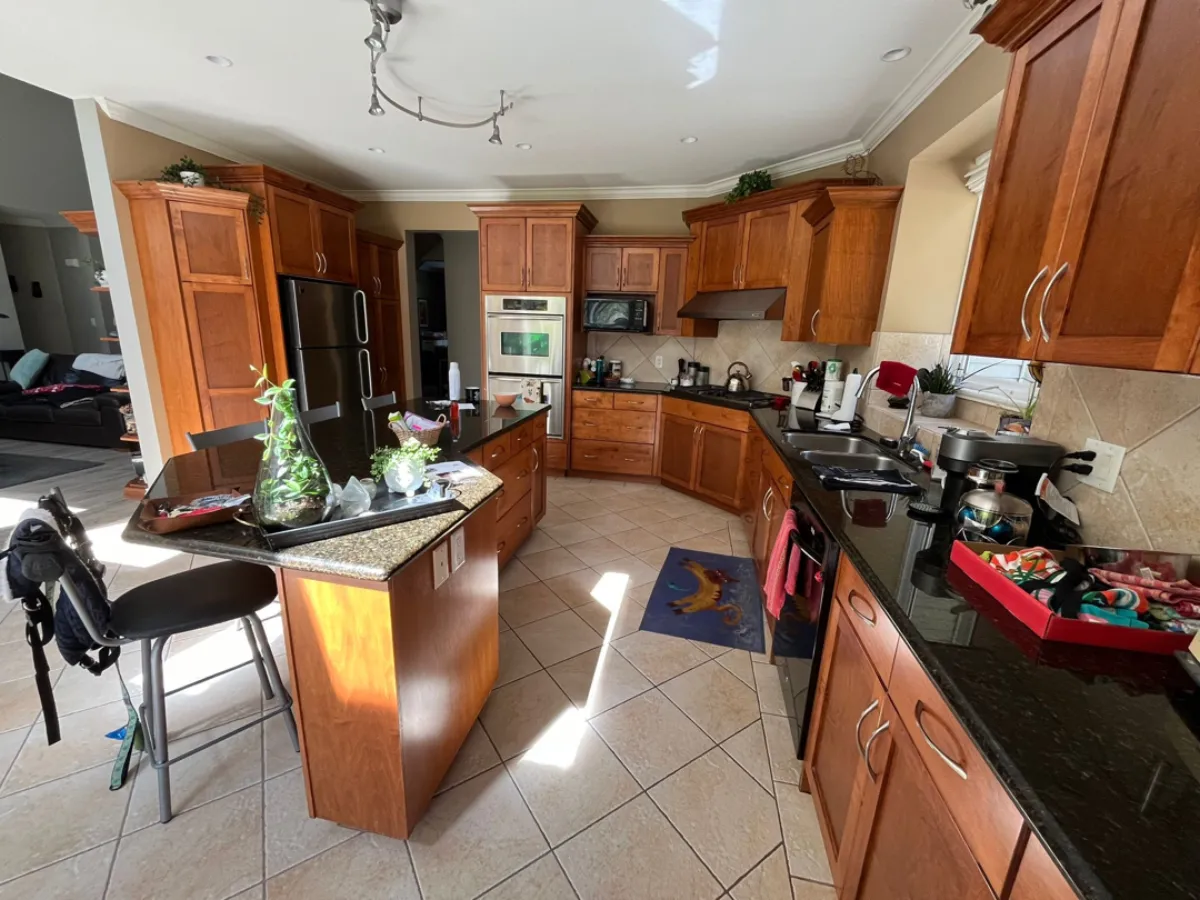 Anmore kitchen before renovation with cherry wood cabinets and tile floor