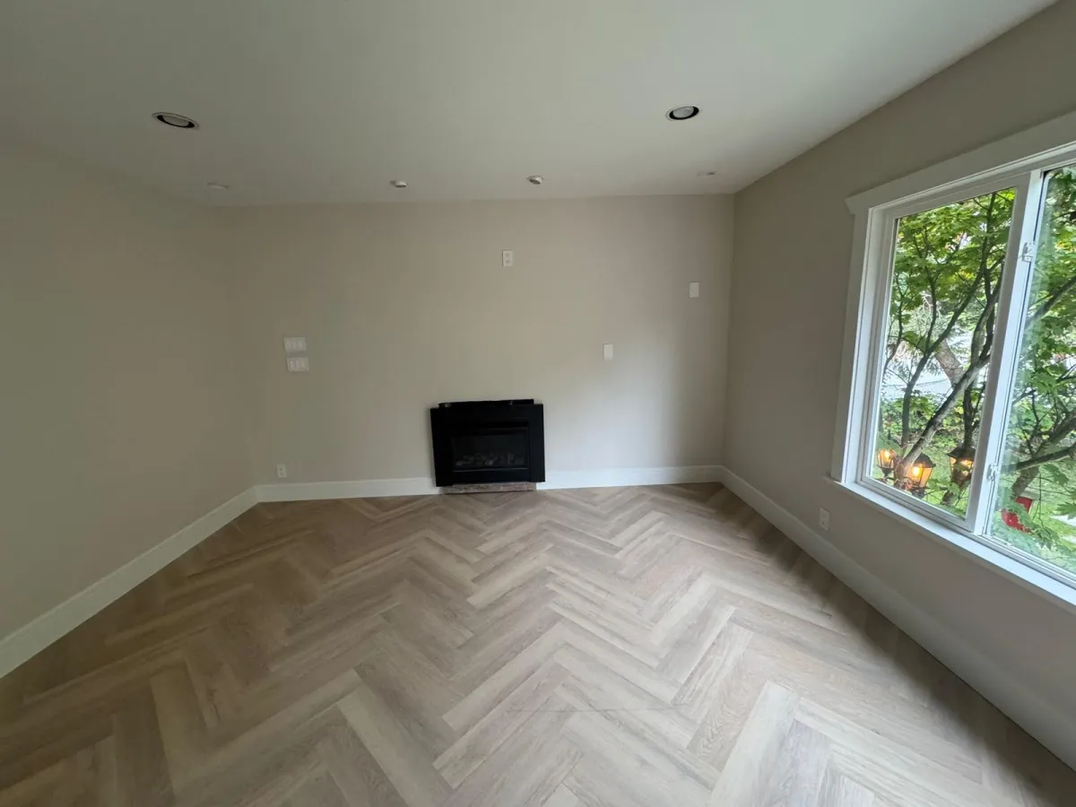 Renovated living room with herringbone flooring and modern fireplace