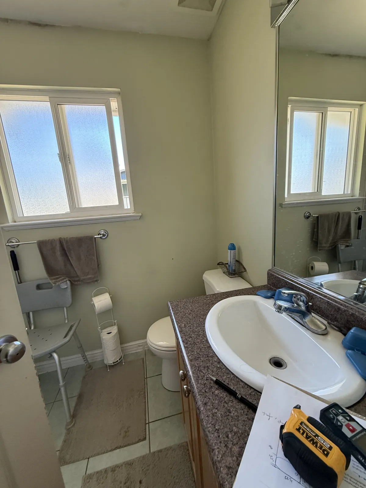 Bathroom vanity area before renovation with brown granite counter and old fixtures