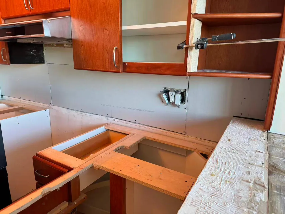 Kitchen cabinets with old countertop removed showing exposed framing