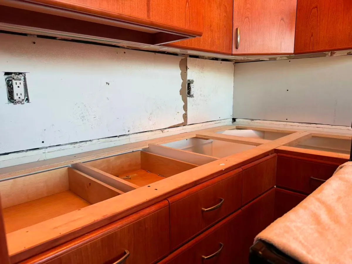 Old countertops removed exposing cabinet framing and backsplash