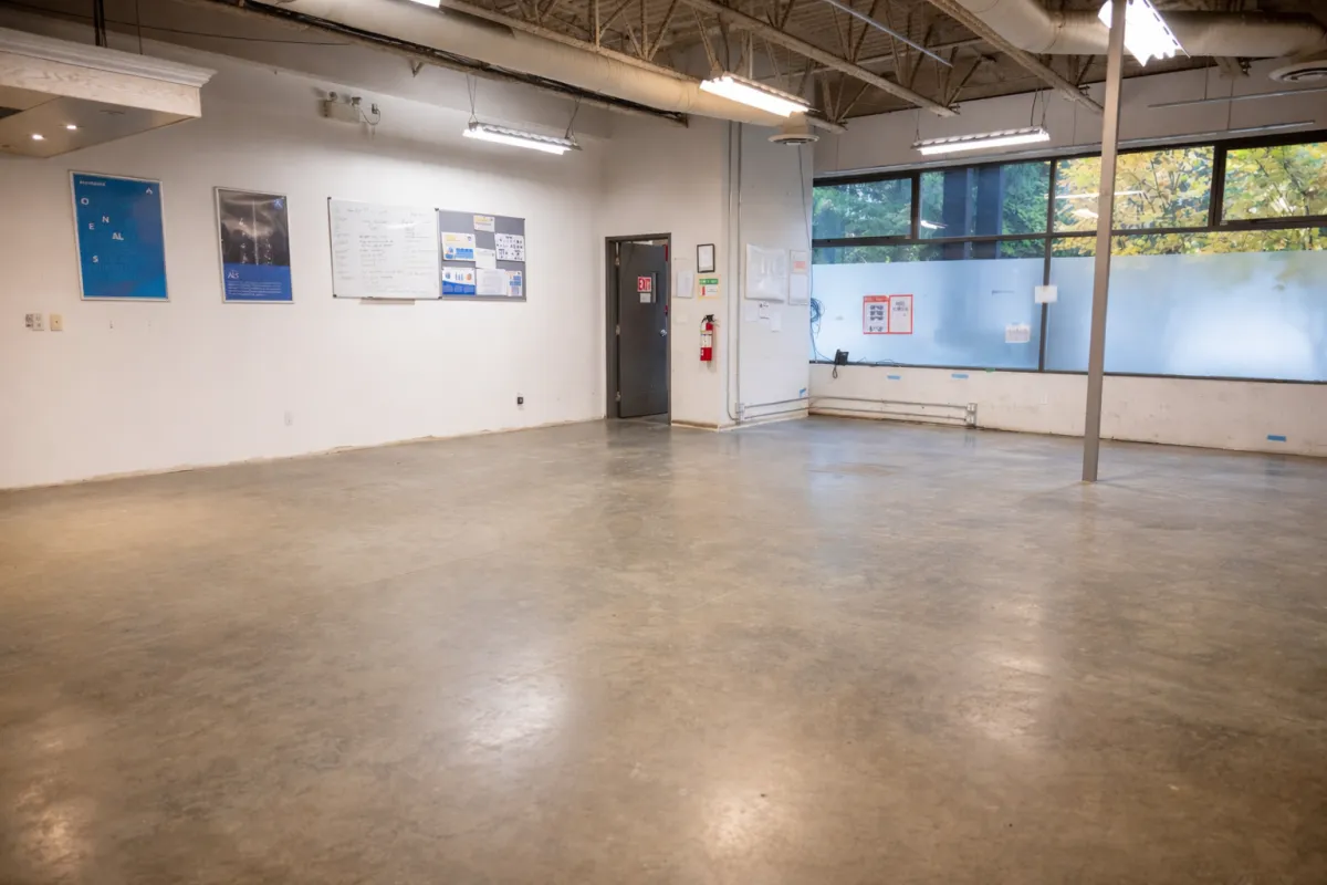Large warehouse main floor with bare polished concrete before flooring installation